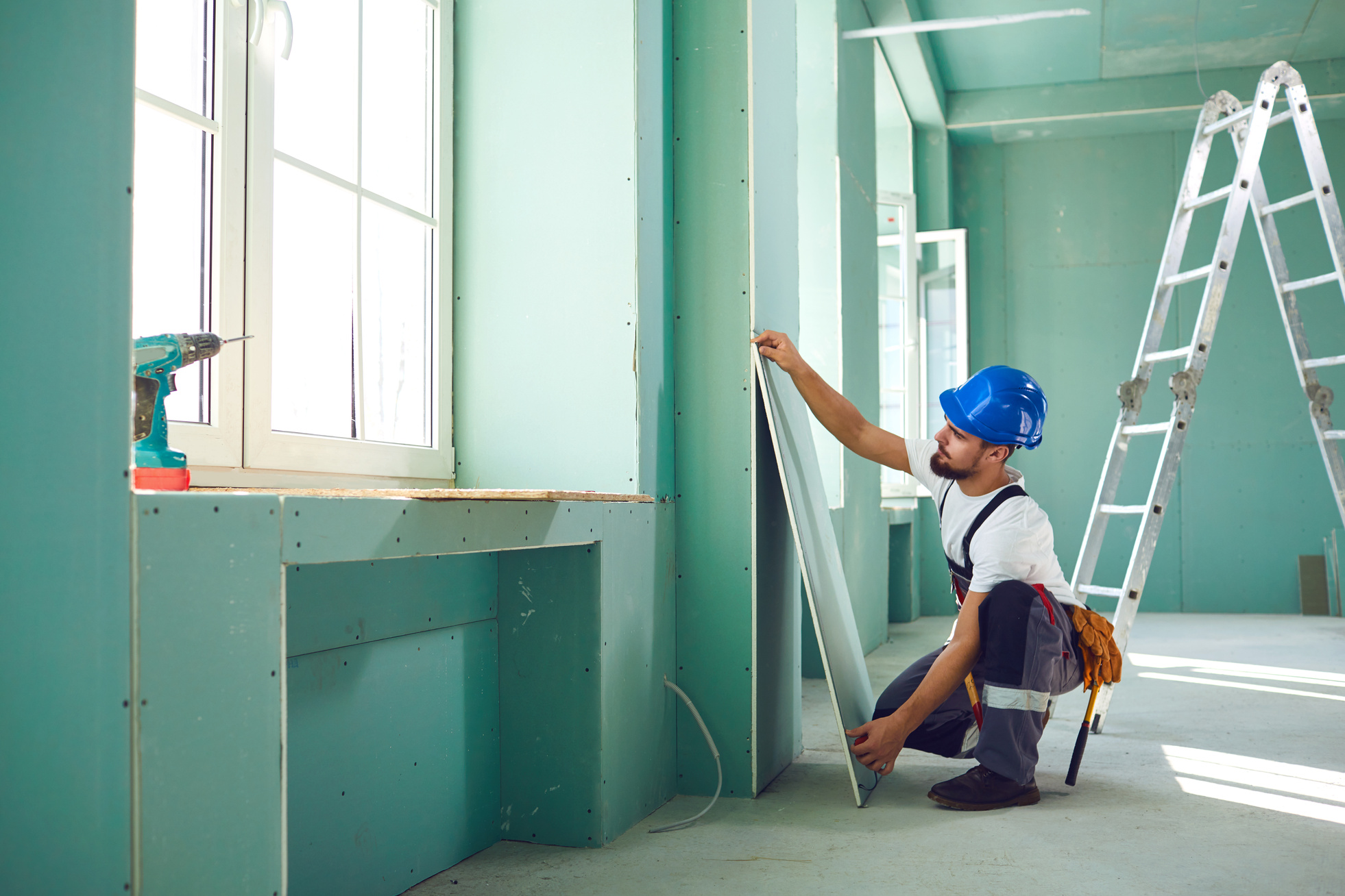Construction Worker Installs Plasterboard Drywall 